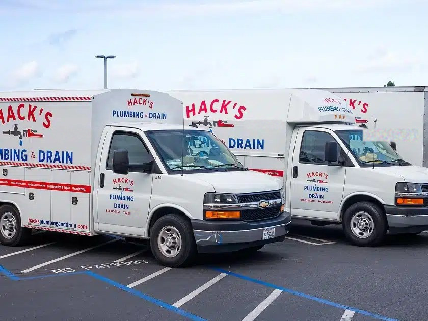 Hack's Plumbing & Drain service vans lined up in the lot