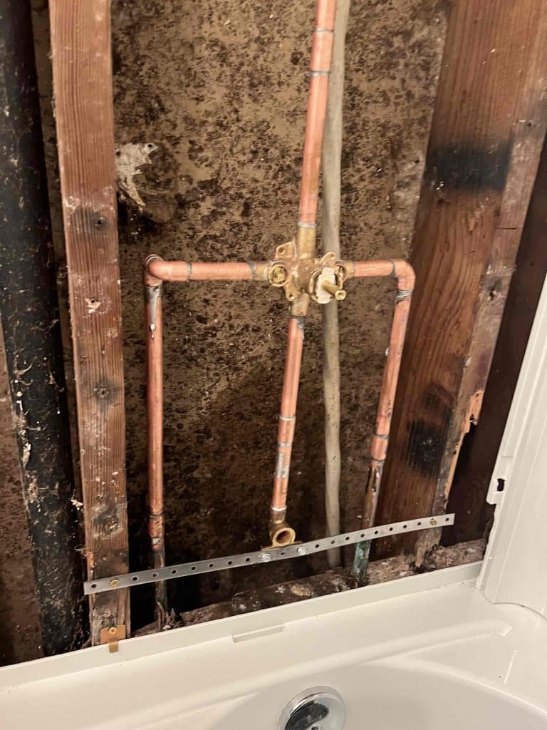 Copper stub-outs in the opened wall above a tub
