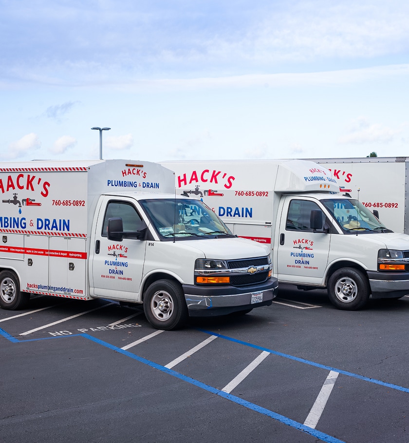 Hack's Plumbing and Drain service vans parked in a lot