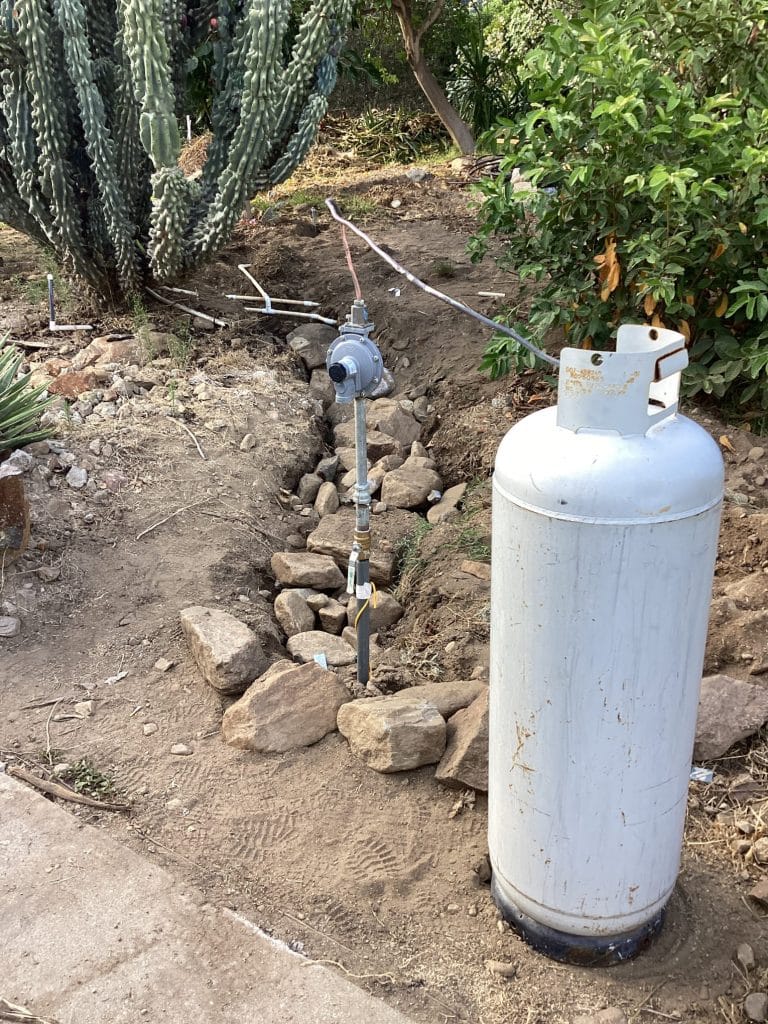 LP tank with the gas line stubbed up beside it