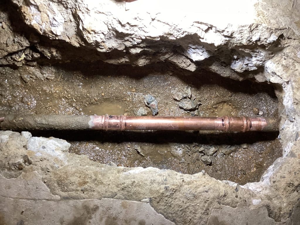 Copper line with a repair coupling in the slab cut