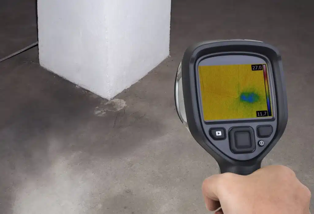 Thermal imaging camera pointed at a concrete floor to find a hidden leak