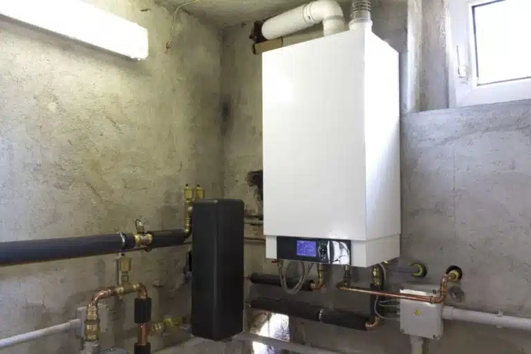 Wall-mounted tankless water heater with its piping in a utility room