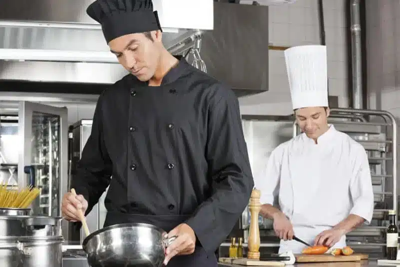 Two chefs cooking in a commercial kitchen