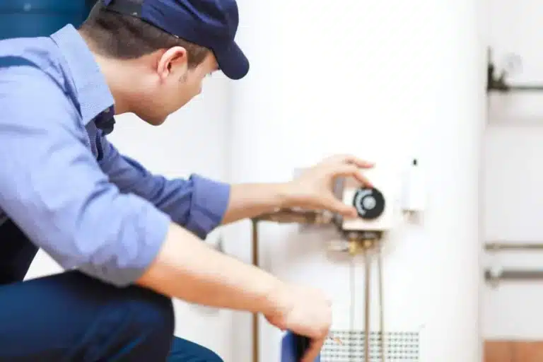 Plumber adjusting the dial on a wall-mounted water heater